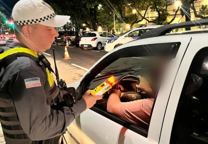 Policial aborda motorista para fazer o teste no etilômetro passivo, que acusa presença de álcool a distância