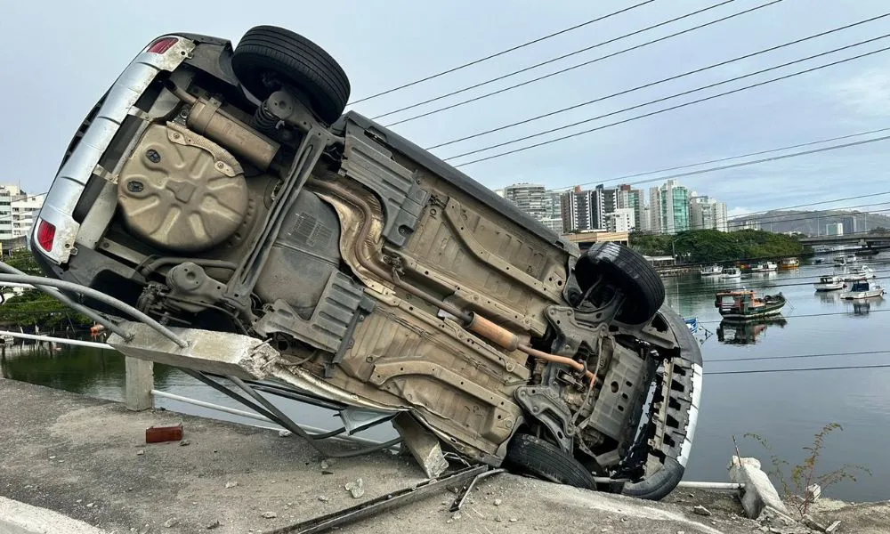 Imagem ilustrativa da imagem FOTOS | Carro de médica capota e fica pendurado em ponte de Vitória