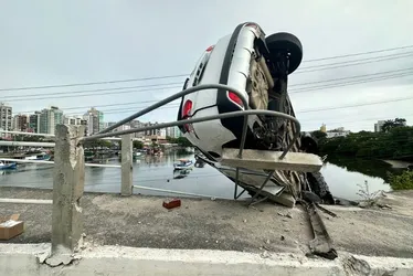 Imagem ilustrativa da imagem FOTOS | Carro de médica capota e fica pendurado em ponte de Vitória