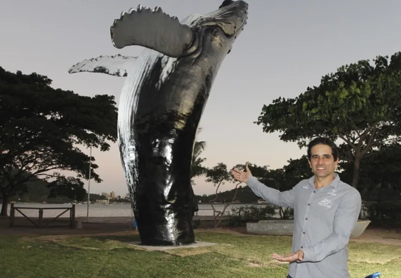 Paulo Rodrigues, coordenador do projeto Baleia Jubarte, ao lado da escultura gigante de baleia na Praça do Papa