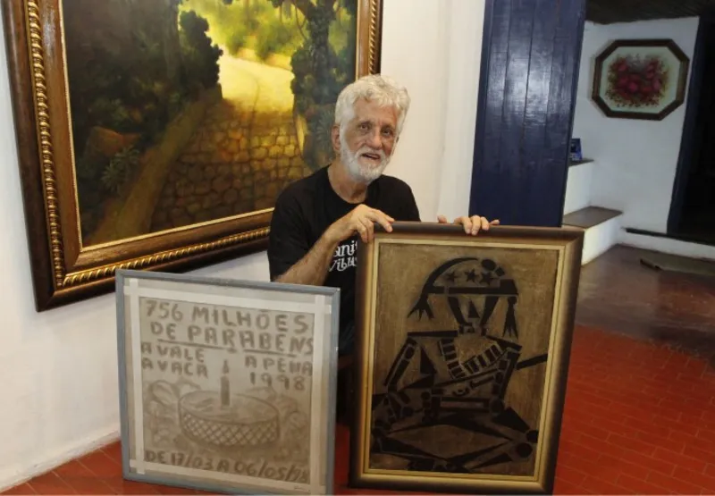 Kleber Galvêas mostra quadro feito com pó de minério e com o primeiro asfalto da avenida Champagnat