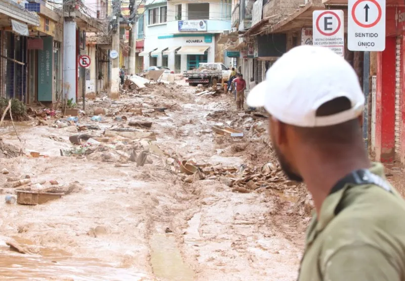 Morador de Mimoso do Sul observa com tristeza rua cheia de lama após enchente na madrugada de sexta-feira