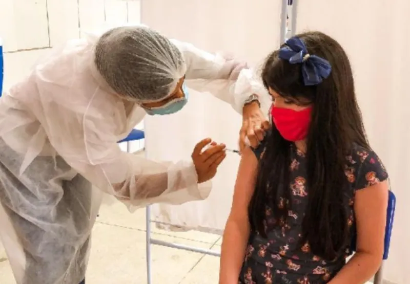 Criança de 10 anos sendo vacinada contra a dengue em Paulista