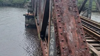 Imagem ilustrativa da imagem Mulher cai de ponte ao tirar foto e se segura em cadarço até ser resgatada por bombeiro; veja vídeo