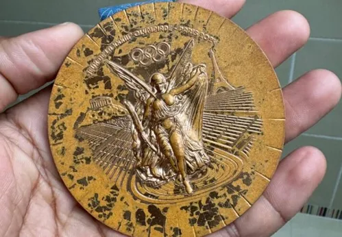 
          Imagem ilustrativa da imagem Atletas franceses mostram péssimo estado das medalhas conquistadas nos Jogos de Paris; veja
          