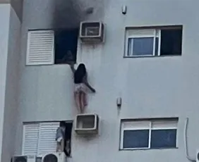 Imagem ilustrativa da imagem Vídeo: mulher se pendura em ar-condicionado no 12º andar para salvar mãe e criança de incêndio