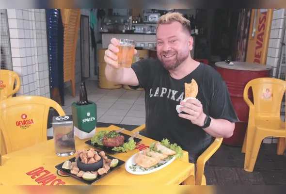 Shaun Alexander prova as delícias do Bar dos Coroas, local onde gravou  vídeo mostrando uma roda de samba