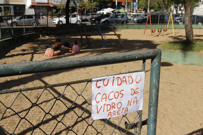a Praça Wolghano Netto, em Jardim da Penha, um cartaz alerta para o risco de cacos de vidro na areia do parquinho