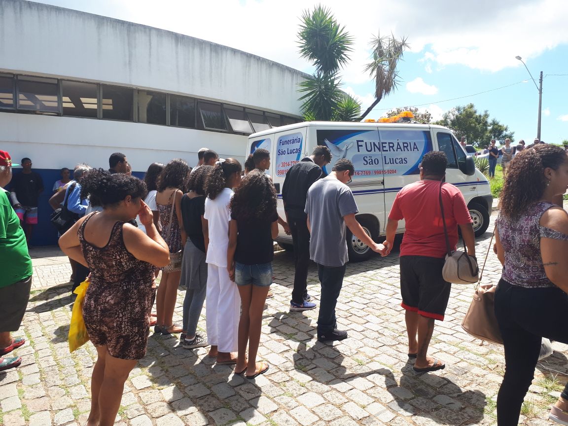 De mãos dadas, irmãos de Ruan e Damião seguiram o carro a funerária até o local do sepultamento. Foto: Thaís Cardoso