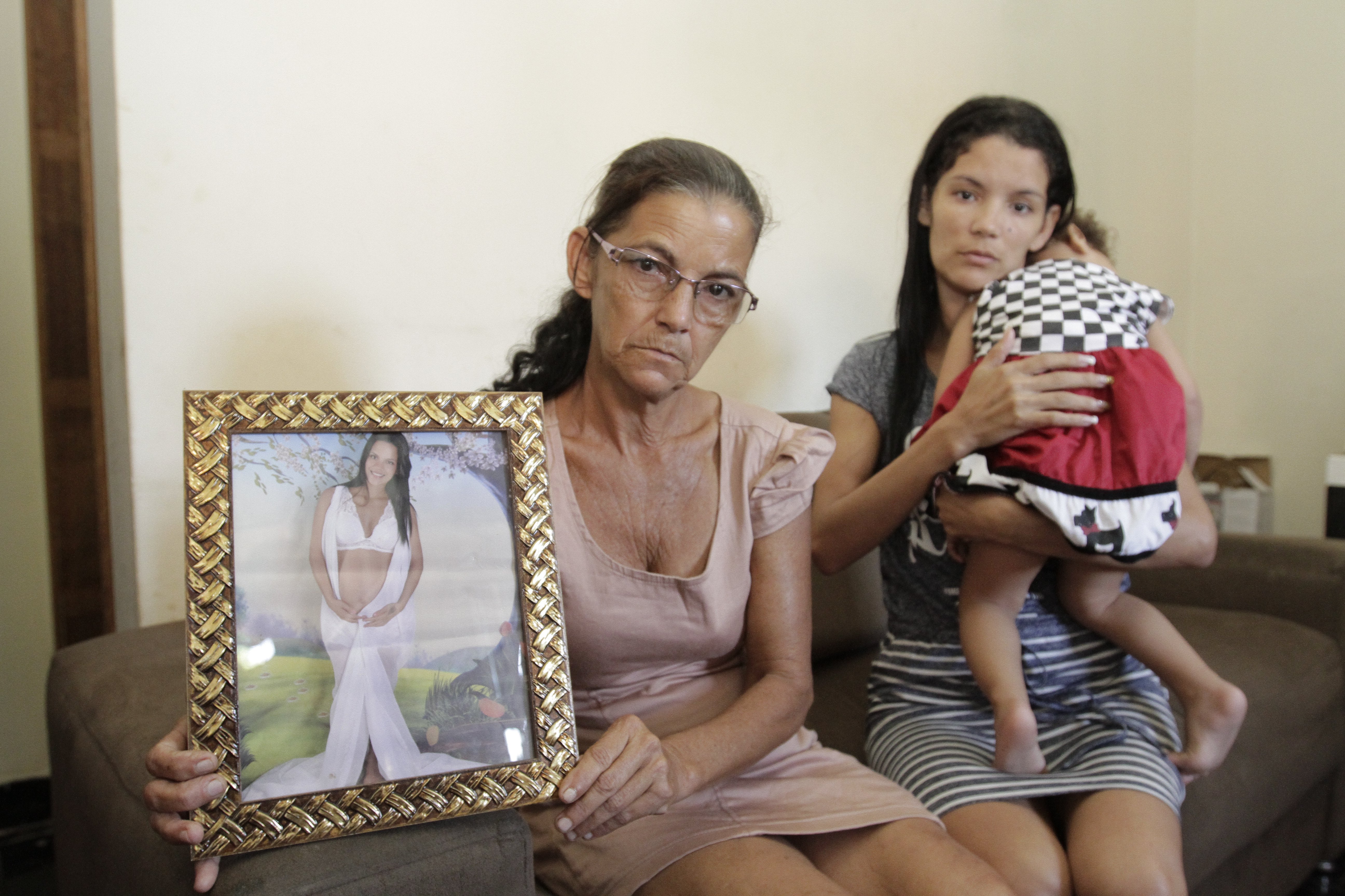 Erly Pereira Costa, 53, mostra a foto da filha Gleiciany, que morreu. Sabrina Pereira Costa, 30, segura no colo a filha da irmã. Foto: Beto Morais/AT
