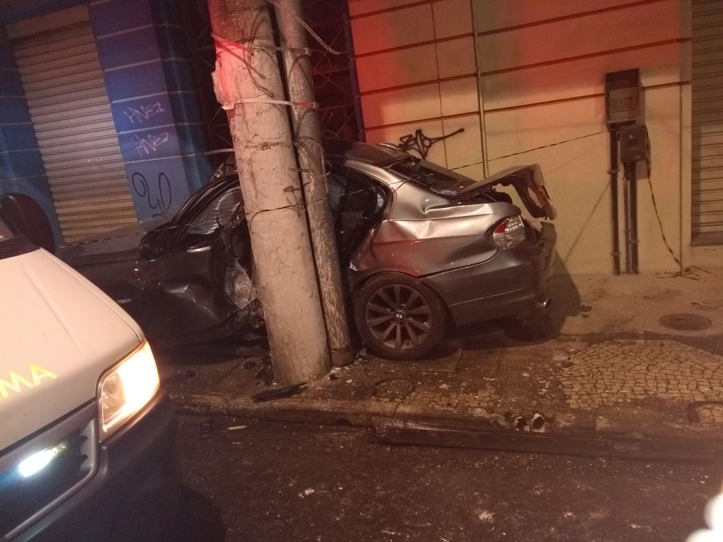 A BMW invadiu a calçada e ficou imprensada entre um poste e uma parede. Foto compartilhada via WhatsApp