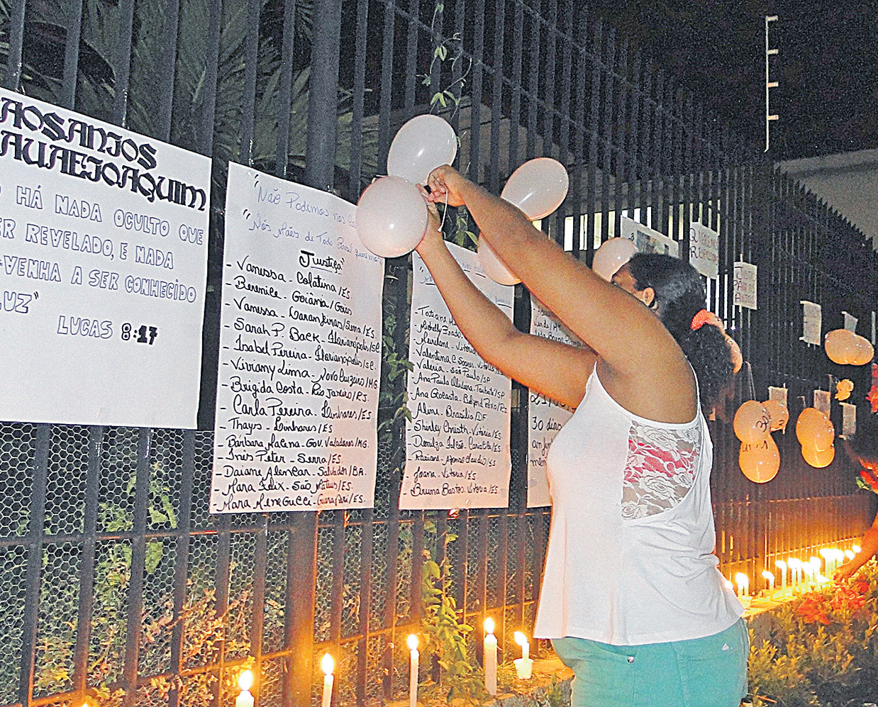 Manifestantes colocam balões e cartazes na grade da casa onde os meninos morreram queimados. (Foto: Wilton Junior)