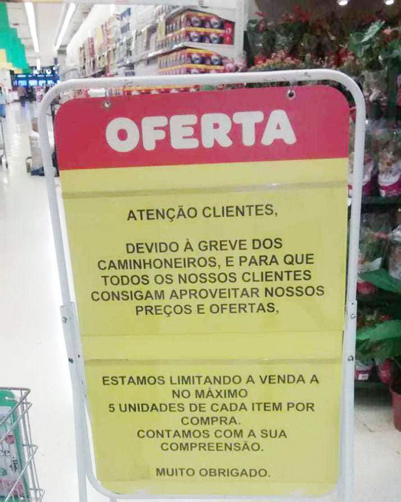 Placa está fixada em diversos estabelecimentos da rede (Foto: WhatsApp)