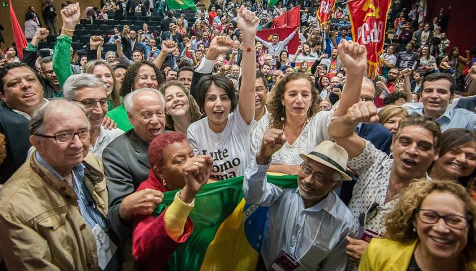 Manuela é saudada ao lado de militantes do PC do B (Foto: Divulgação / Facebook)