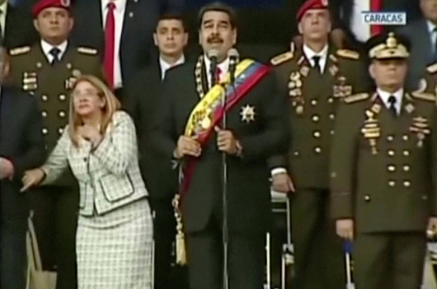 Em imagem retirada de vídeo, Nicolás Maduro e sua mulher, Cilia Flores, reagem após ouvir explosão. (Foto: Reprodução)