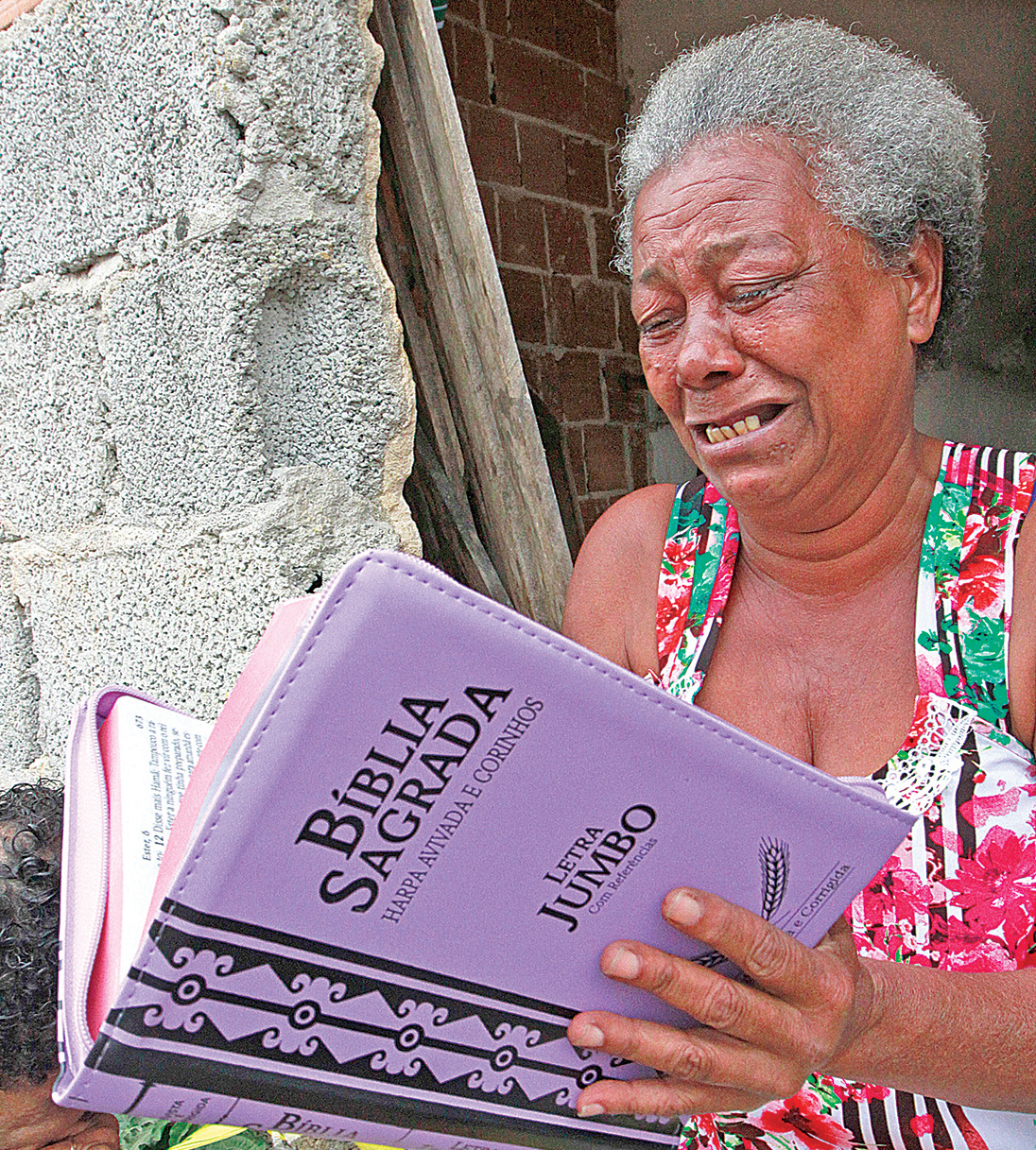Dona Vanda Silva de Jesus chora de emoção ao receber a Bíblia nova, junto com roupas e a promessa de construção de uma nova casa, após incêndio consumir tudo o que ela tinha. (Foto: Antonio Moreira)