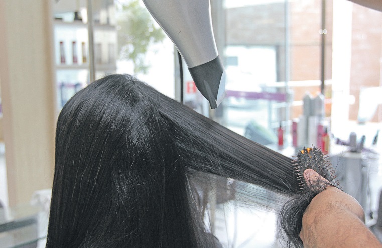 Cabeleireiro faz alisamento. O procedimento já levou a queda de cabelo, alergia e calvície parcial em mulheres (Foto: Dayana Souza - 07/06/2018)