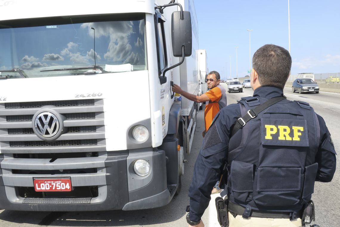 Agente da Polícia Rodoviária Federal orienta caminhoneiro em rodovia (Foto: Vladimir Platonow / Agência Brasil/Agência Brasil)