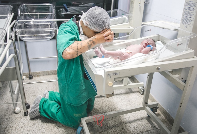 Victor faz uma oração ao lado do filho recém-nascido (Foto: Janaína Brasil / Divulgação)