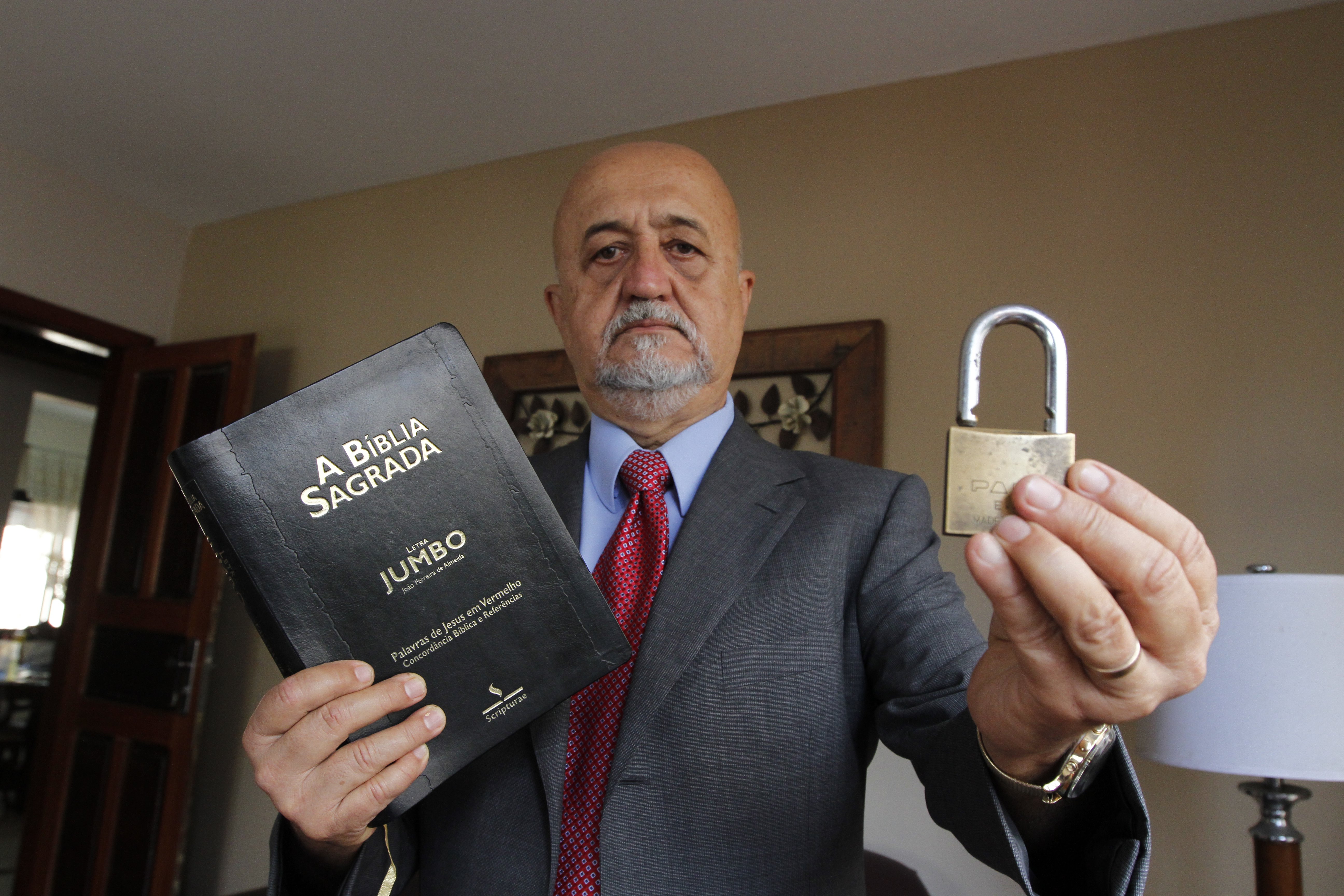 Pastor Enoque de Castro com Bíblia e cadeado: número de invasões pode ser maior por falta de registro na polícia. (Foto: Rodrigo Gavini/AT)