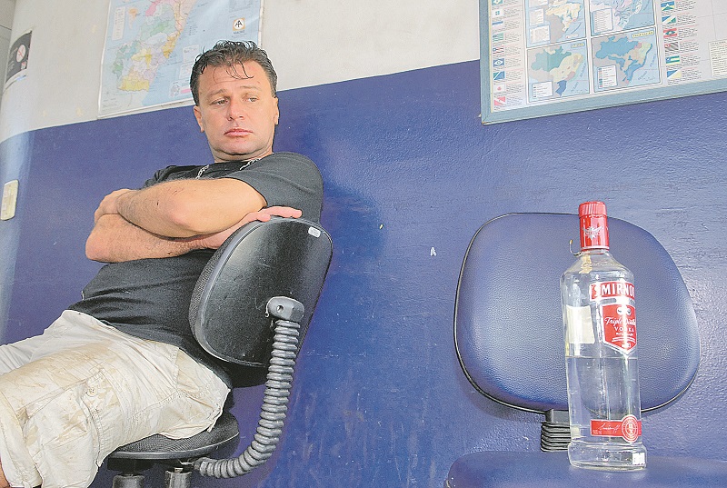 agner Dondoni no posto da PRF, olhando a garrafa de vodca achada em seu veículo, após acidente, em 20 de abril de 2008 (Foto: Marcelo Andrade - 20/04/2008)