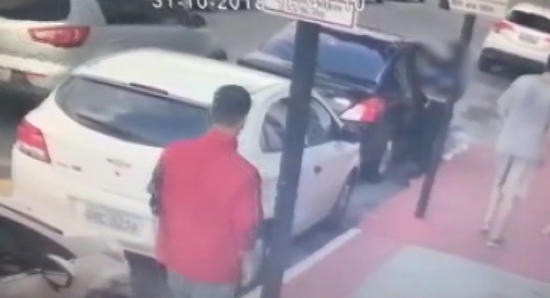 Os dois suspeitos do crime (um de camisa vermelha e outro de camisa cinza) foram filmados pelas câmeras (Foto: Reprodução / TV Tribuna - 01/11/2018)