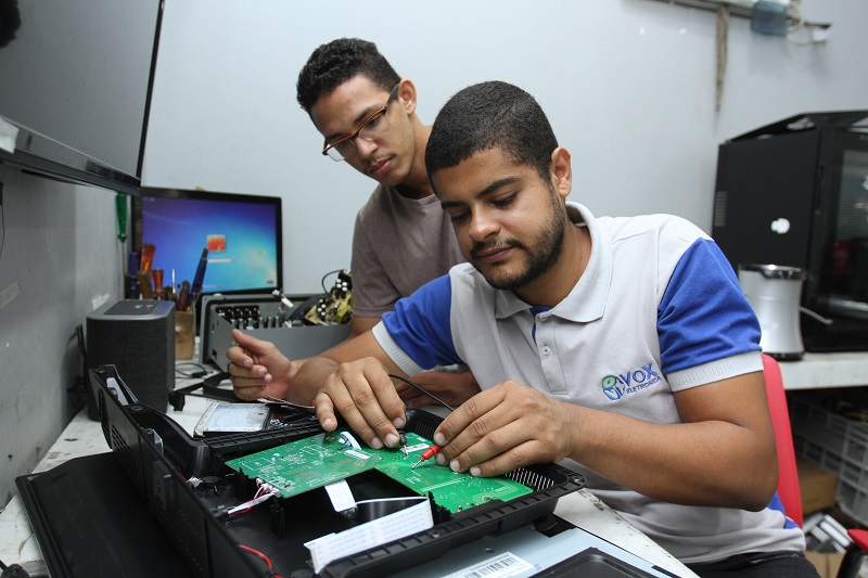 Técnico em eletrônica Robson Kennedy avalia a TV do vendedor Lucas Silvares Rocha (Foto: Antonio Moreira/ AT/ 20/12/2018)
