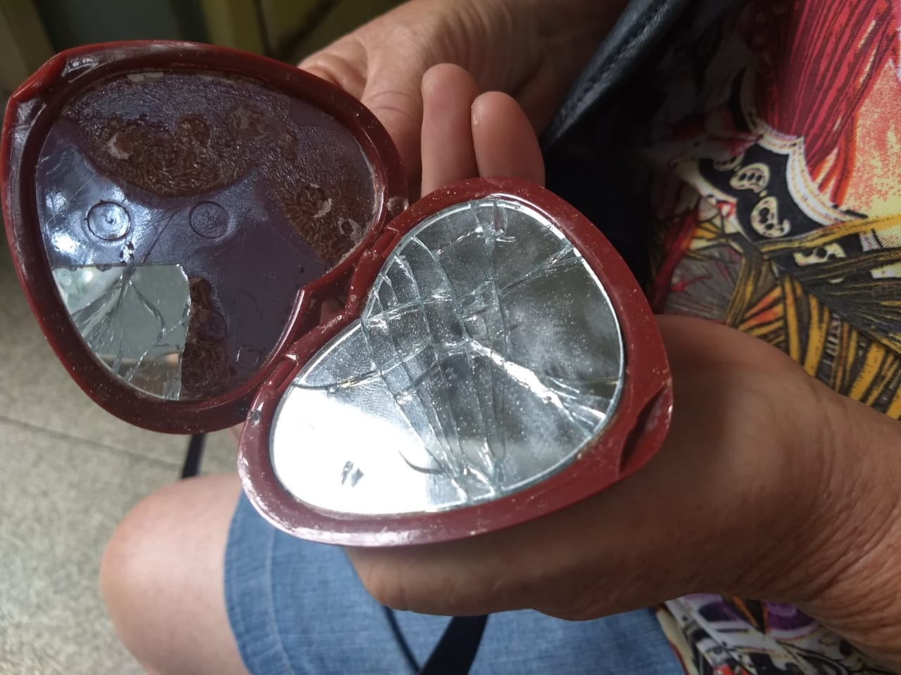 Dona de casa mostra espelho quebrado após carro passar por cima de bolsa (Foto: Tais de Hollanda)