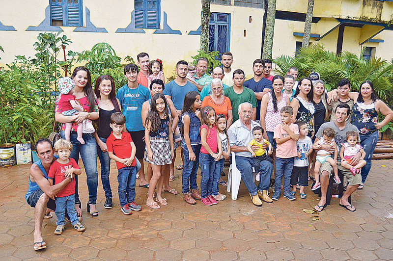 Seu Nengo (sentado) conseguiu reunir 14 dos 33 filhos, netos e bisnetos, além da segunda ex-mulher, Sebastiana Gonçalves (de blusa laranja), e a atual, Nilceia Machado (de blusa branca estampada de rosa) (Foto: Alessandro de Paula / AT)