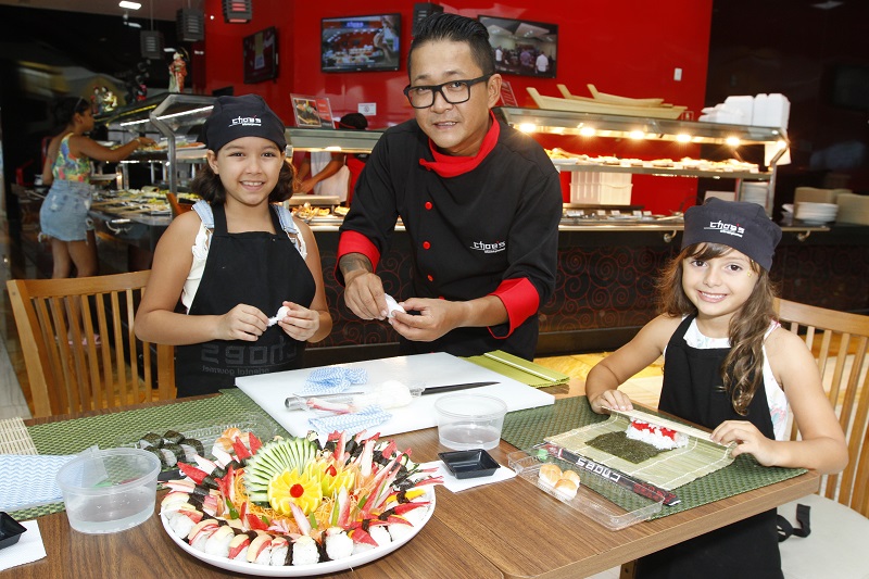As meninas Yasmin e Nalu com o chef Ron Shimizu: aula gratuita para crianças aprenderem a culinária japonesa (Foto: Leone Iglesias/ AT)
