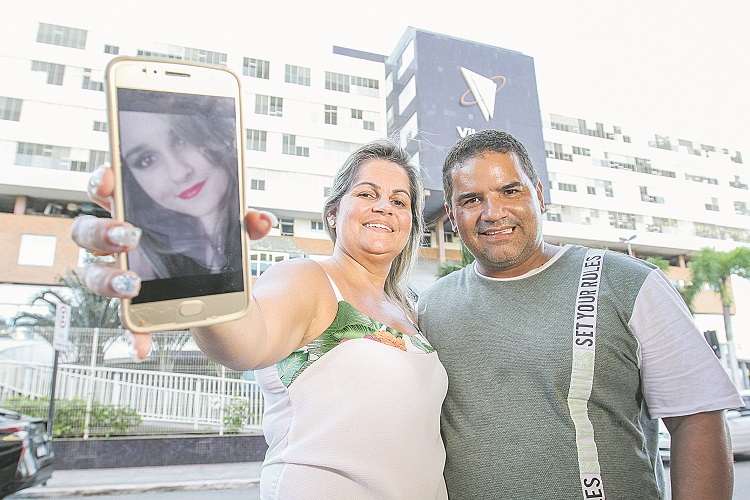 os pais de Larissa, Rutilea Lauret Simões e Leonardo de Oliveira, mostram a foto da filha, que foi submetida à cirurgia (Foto: Beto Morais/AT)