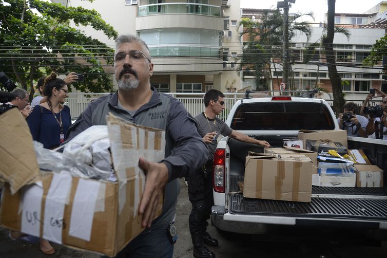 Policiais carregam caixas apreendidas em endereço ligado a suspeito de matar a vereadora Marielle Franco e o motorista Anderson Gomes (Foto: Tânia Rêgo/ Agência Brasil)