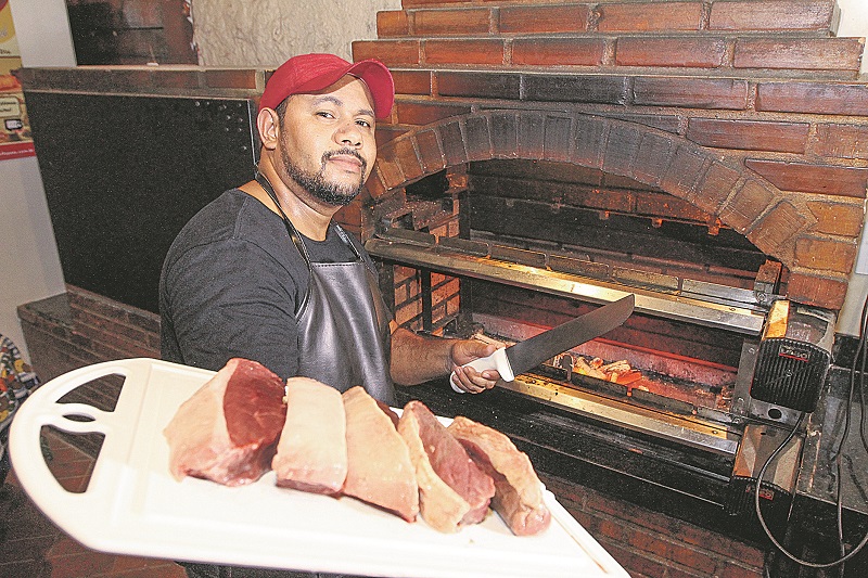 O mecânico Giomarcos Larangeira trabalha como churrasqueiro à noite. Ao todo, acumula seis trabalhos (Foto: Beto Morais/AT)