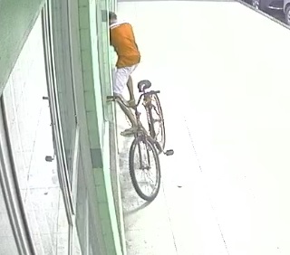 Suspeitos chegaram de bicicleta e um entrou no local (Foto: Videomonitoramento)