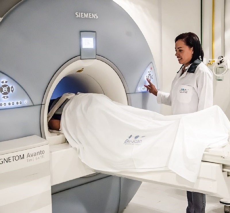 A técnica em radiologia Eliene Santos acompanha paciente durante o exame de ressonância magnética. (Foto: Divulgação)