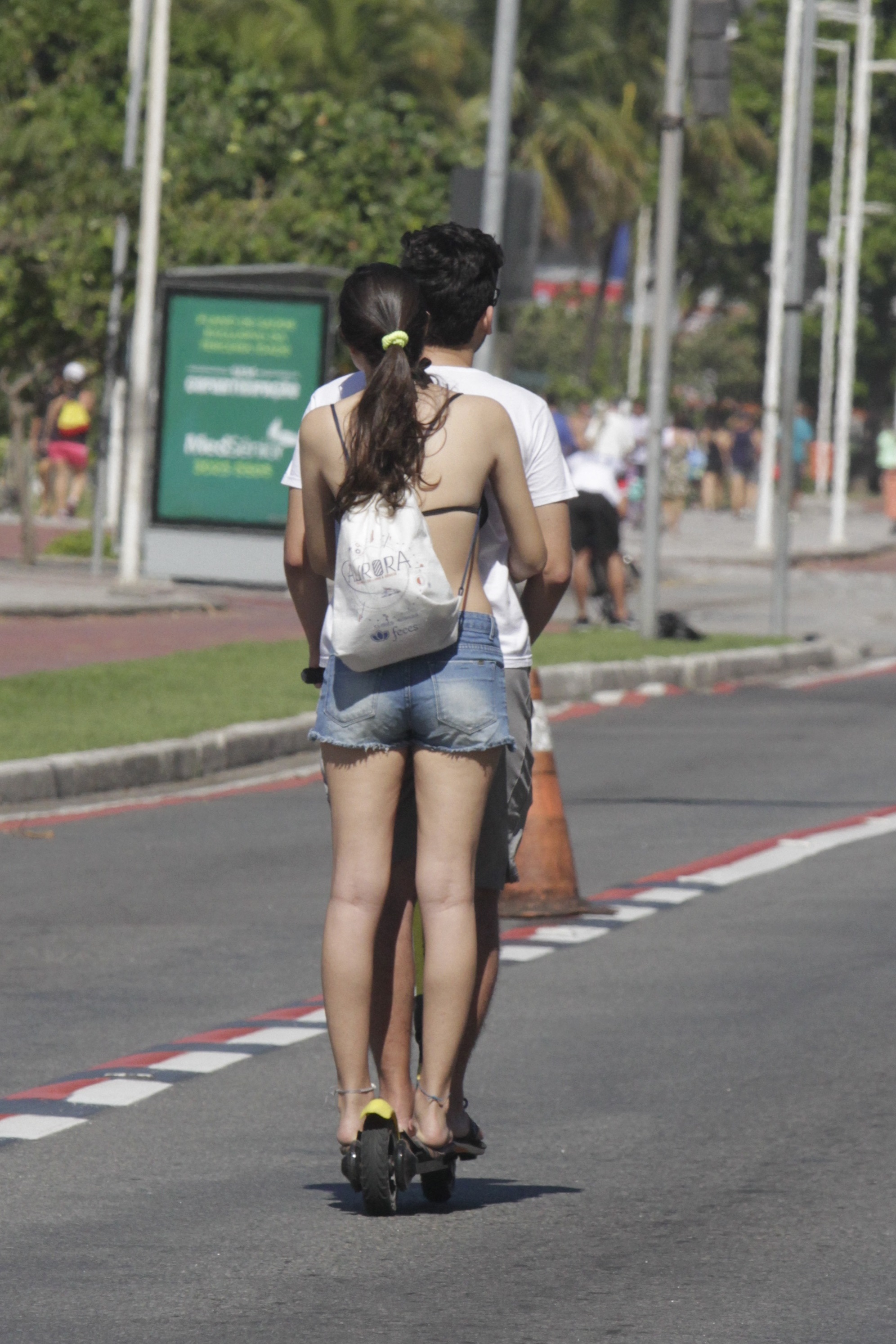 Jovem pega carona em patinete na Praia de Camburi (Foto: Kadidja Fernandes/AT)