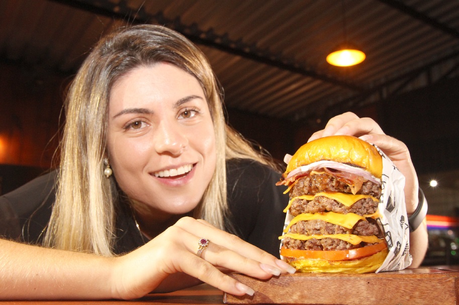 O Show Burger (99636-5623), em Coqueiral de Itaparica, lança hoje o megaquarteirão. Vem com pão amanteigado, quatro burgers bovinos, quatro fatias de cheddar, bacon crocante, barbecue de cachaça, creme de queijo, cebola roxa, tomate e molho especial. O lanche foi aprovado pela advogada Evelyn Negrelli, 28.  Para quem pagar com dinheiro,  sai a  R$ 26,90. Com pagamento no cartão, fica por R$ 30,00. O sanduíche ficará  no menu até a próxima terça. (Foto: Beto Morais/AT)
