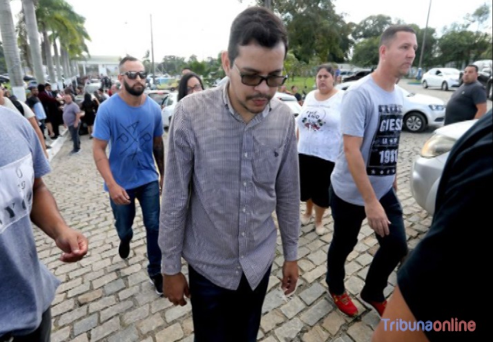 Flávio Rodrigues é levado para prestar depoimento após o enterro do corpo de seu pai (Foto: Wilton Júnior / Estadão Conteúdo)