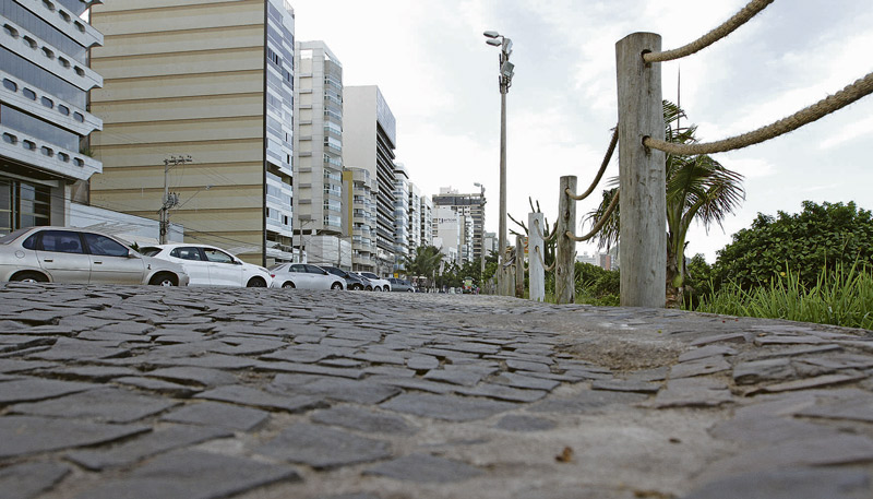 Desníveis no piso do calçadão da Praia da Costa e mato alto, que levam risco para pedestres e insegurança (Foto: Beto Moraes / AT)