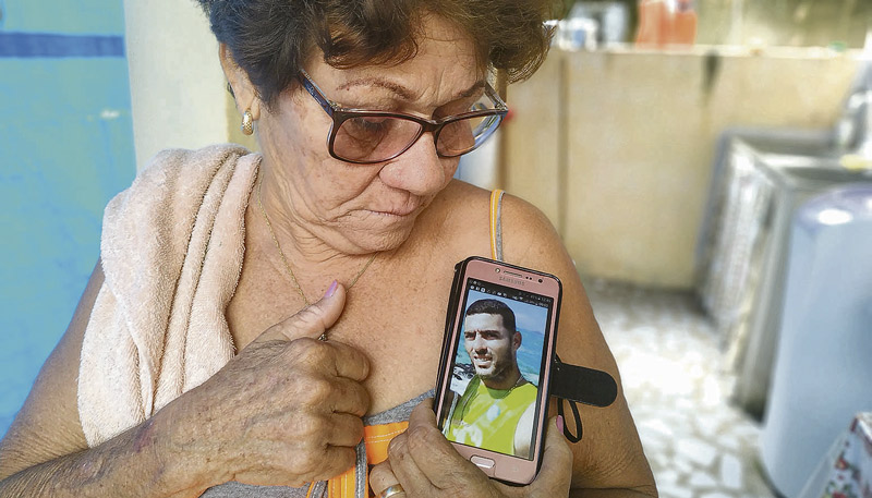 Professora Maria de Moura segura o celular com a foto do filho Éder Henrique Moura, sequestrado no sábado (Foto: Kananda Natielly)