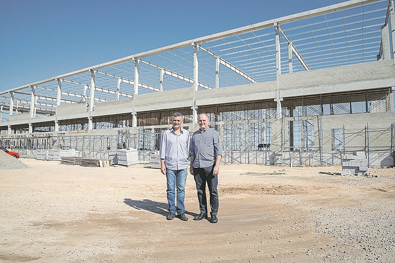 Audifax e Checon em frente às obras de novos armazéns no Tims, que terão concessionárias de veículos (Foto: Everton Nunes/ Secom-PMS)