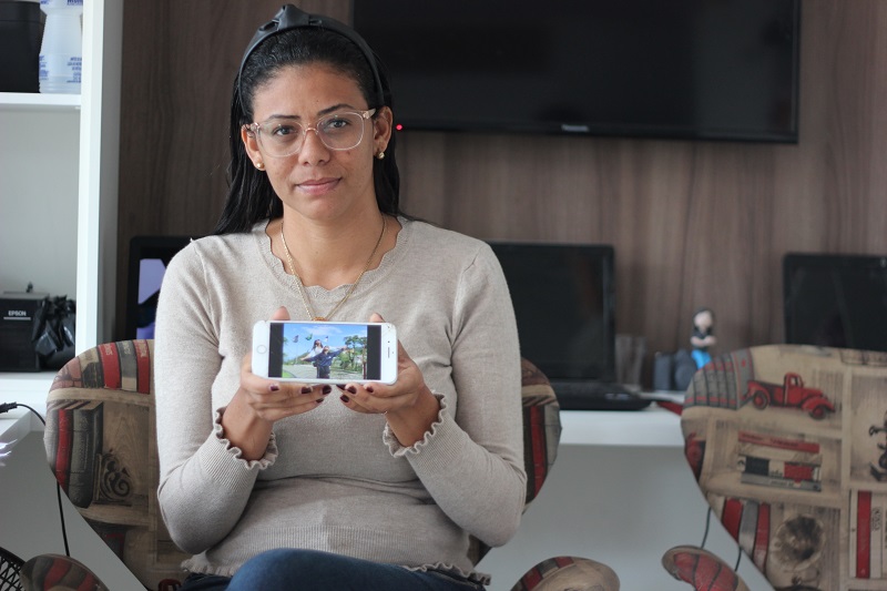 A fotógrafa Cida Rocha mostra no celular a foto com o filho: “Nas minhas redes sociais, estou conversando com as pessoas sobre essa doença do século” (Foto: Roberta Bourguignon)