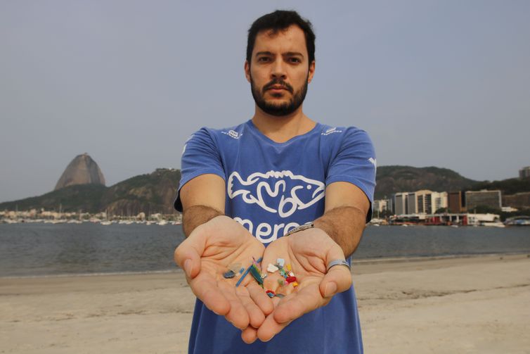 (O biólogo Jonas Leite, doutor em oceanografia, presidente do Instituto Meros do Brasil, mostra microplástico vindo do mar e coletados na areia da praia de Botafogo - Fernando Frazão/Agência Brasil)