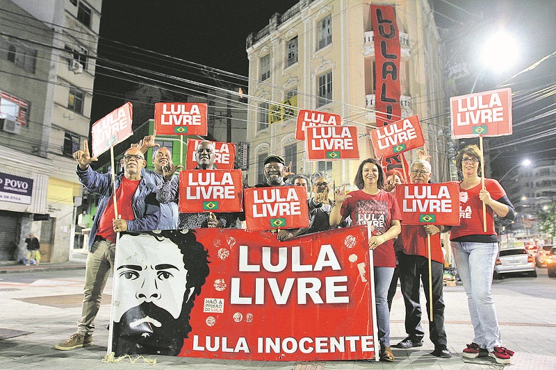 Ativistas do Comitê Lula Livre comemoram recolocação de faixa, retirada por membros do Direita-ES. (Foto: Dayana Souza/AT)
