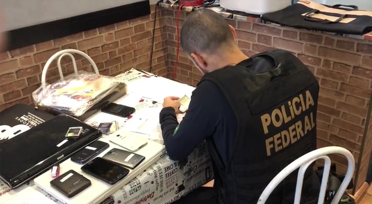 Policiais federais cumprem mandados de busca e apreensão em endereços dos investigados (Foto: Divulgação/ Polícia Federal)