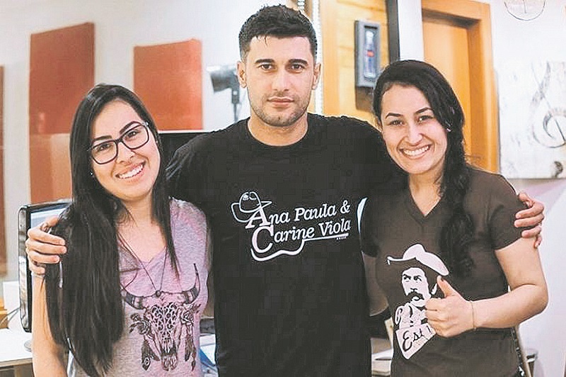O produtor musical com a dupla Ana Paula e Carine Viola. “Já teve contratante que perguntou se eu era do mal, mas de brincadeira”, contou Hitler. (Foto: Divulgação)