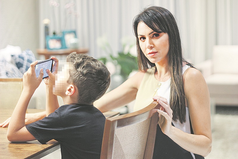 Ao lado do filho, Regina alerta os pais a sempre acompanharem o que as crianças estão fazendo no celular (Foto: Roberta Bourguignon)