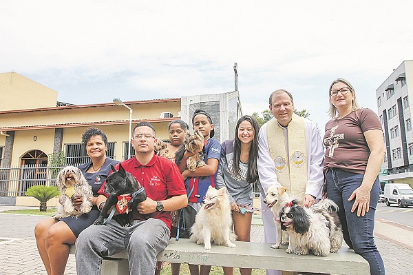 O padre Celso Nogueira ao lado de fiéis da Paróquia São Francisco de Assis e dos cães que receberão bênção (Foto: Antonio Moreira/AT)