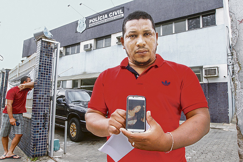 Vanderclei mostra a foto da filha no celular: tatuagem no corpo de Karolini ajudou o pai a reconhecer a vítima (Foto: Thiago Coutinho/AT)