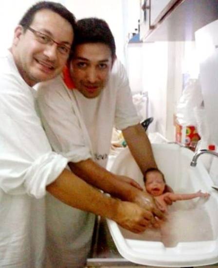 O casal Damián Pighin e Ariel Vijarra com a bebê ainda recém-nascida. (Foto: Reprodução/Redes Sociais)